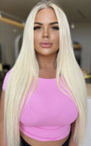 Blonde woman in pink shirt with freshly foiled hair, showcasing the 'Blonde Foiled Queen' service at Kasey Lee Blonde Specialist